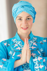 Portrait of a beautiful young woman. Woman in blue colored clothes of the east asian type.
