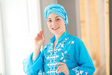 Portrait of a beautiful young east woman. Woman in blue colored clothes and turban of the east asian type.