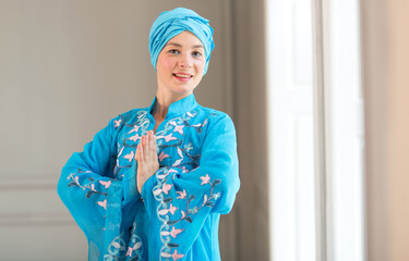 Portrait of a beautiful young east woman. Woman in blue colored clothes and turban of the east asian type.