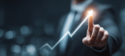 Businessman touching a glowing upward arrow graph symbolizing business growth, success, and financial progress

