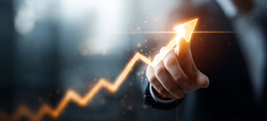 Businessman touching a glowing upward arrow graph symbolizing business growth, success, and financial progress

