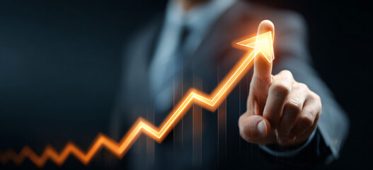 Businessman touching a glowing upward arrow graph symbolizing business growth, success, and financial progress

