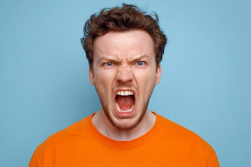 A man with an angry expression shouts with his mouth wide open
