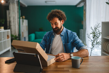 Man unboxing parcel at home following online order