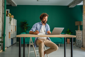 Freelancer working from home having video call using laptop and headset