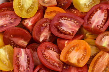 Background of red, orange, yellow juicy tomato sliced. Tomato slices , ripe tomatoes cut.