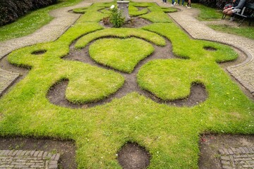 Figure made of green lawn grass in the park, free space. Green grass covered topiary, landscape design. Grass figure, topiary figure.