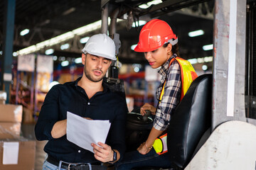 Warehouse supervisor and female forklift operator reviewing documents. Concept of teamwork,...