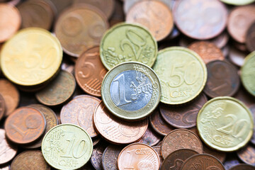 Assorted euro coins in a colorful mix of denominations including 1 euro, 50, 20, 10, 5, 2, and 1 cent. European currency displayed in a macro view with detailed metallic textures