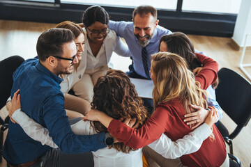 Naklejka na ściany i meble Diverse Business Team Forming a Group Embrace for Unity and Support
