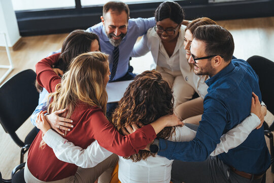 Team Embracing in a Circle During a Motivational Group Meeting