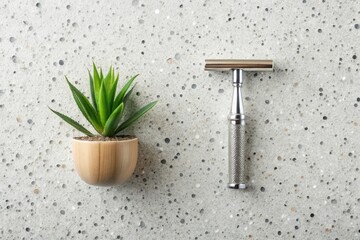 stainless steel safety razor on white terrazzo background, a single aloe vera leaf and natural shaving brush with wooden handle
