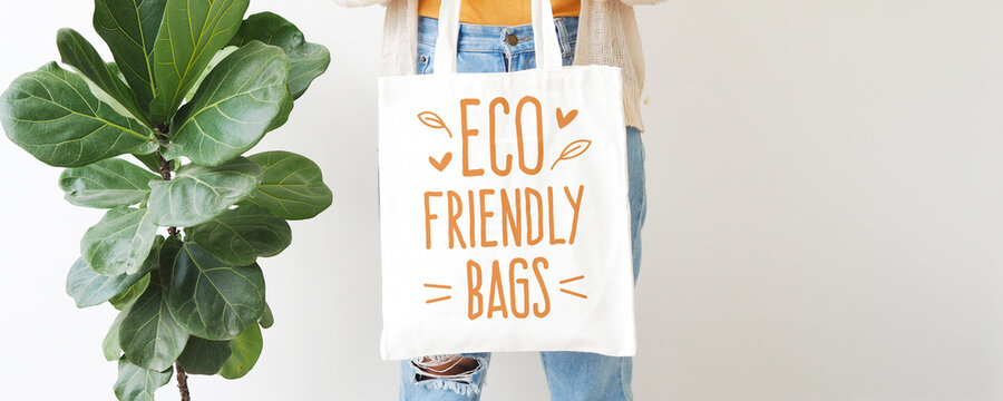 Woman holding canvas tote bag on white background. Reusable eco bag for shopping. Eco friendly concept. 