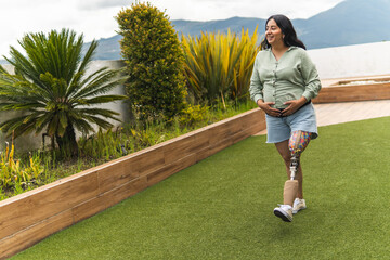 Pregnant woman with prosthetic leg walking in garden