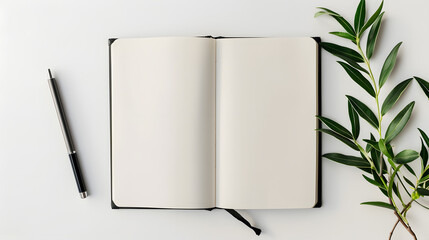 Flat lay of a blank open notebook with a pen and a green branch on a white background, a concept of creativity and journaling.