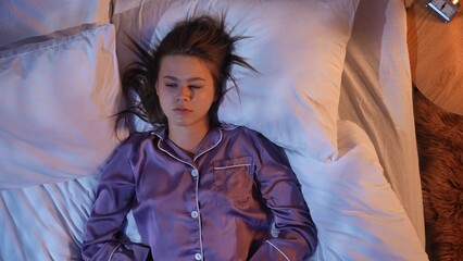Young woman lying awake in bed suffering from insomnia