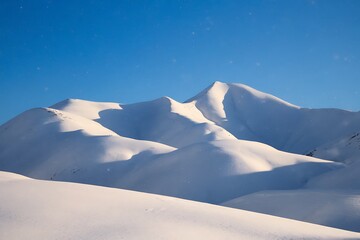 Majestic Snow-Covered Mountain Range Under a Clear Blue Sky