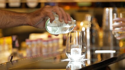 Closeup bartender hand in poring fresh soda gas texture into glass of drink advertisement serving...