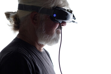 head profile of bearded elderly man operating FPV drone in googles on his head, studio shot of man and modern technologies