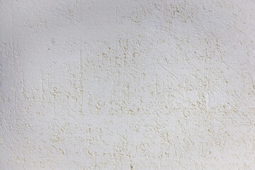 A close-up view of a white, textured wall surface with slight discoloration and imperfections
