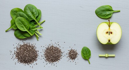 Top view flat lay of healthy green smoothie ingredients. Fresh spinach, apple, and chia seeds arranged on a grey slate background. Concept of diet, detox, and clean eating.