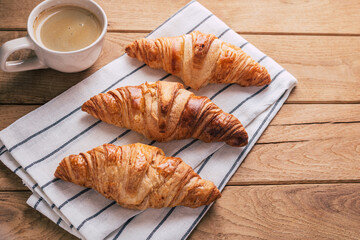 fresh croissants on wooden background