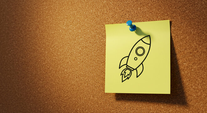Rocket doodle on yellow sticky note pinned to corkboard background  
