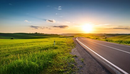 green meadow with asphalt road at sunset in belarus