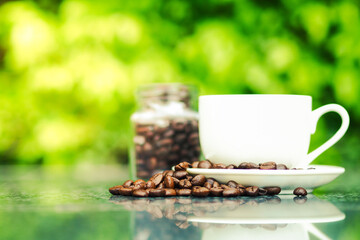 Coffee cup on the table and green nature background