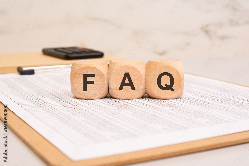 Poster wooden blocks with faq on a financial document. frequently asked questions concept.