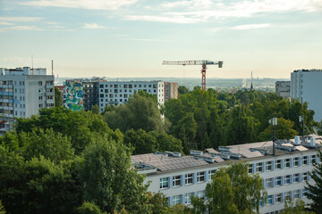 Urban cityscape with modern apartment blocks, a construction crane, and solar panels on a rooftop...