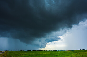 Dark supercell storm clouds with massive rain shaft.