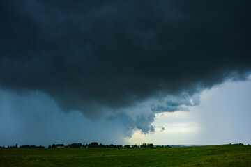 Dark supercell storm clouds with massive rain shaft.