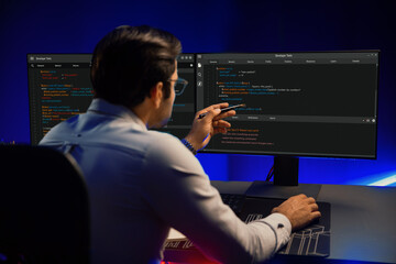 Working smart IT developer pointing data software development on two pc screen, creating...