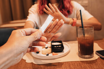 Woman refusing a sugar packet while having a dessert and iced coffee at a cafe, promoting healthy eating habits and sugar-free lifestyle