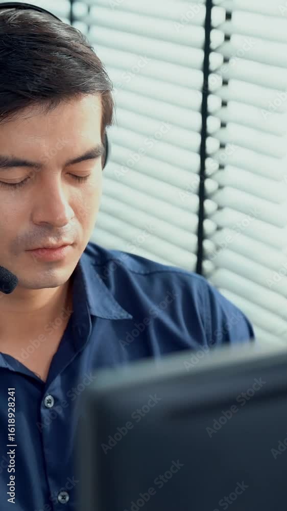 Aufkleber young competent asian male call center agent working at his computer while simultaneously speaking w