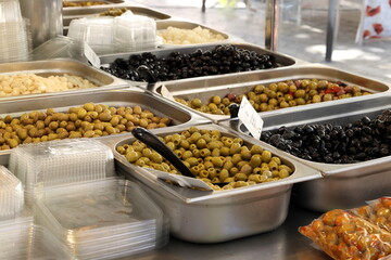 Variety of olives displayed at french market in sunlight