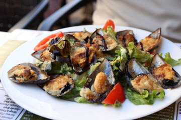 Delicious baked mussels au gratin in french restaurant