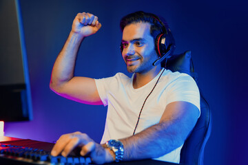 Winner of smart streamer playing online game wearing headphones raising fist up on streaming gamer...