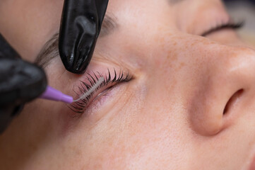 The process of professional eyelash lamination in a salon. 