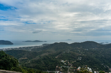 A scenic elevated view capturing a coastal town of Phuket, a vast Andaman sea and distant islands...