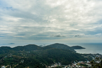 A scenic elevated view capturing a coastal town of Phuket, a vast Andaman sea and distant islands...
