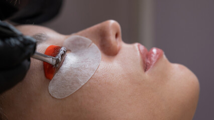 Caucasian woman undergoing eyelash lamination procedure. 
