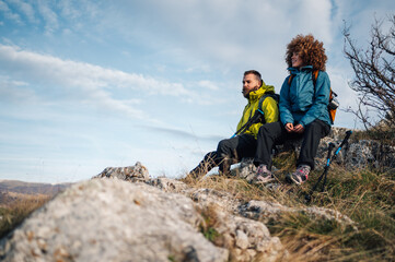 Hikers resting on mountain top enjoying scenic view
