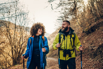 Hikers walking and smiling in forest during trekking day