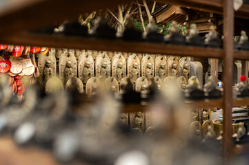Japanese Temple Detail with Stone Monk Statues and Daruma Dolls in Background