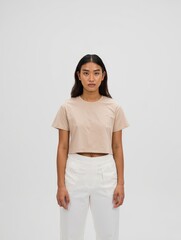 Young Woman in Minimalist Fashion Standing Against Plain Background