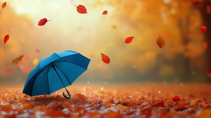 Blue Umbrella in Autumn Leaves With Orange Foliage Swirling in the Breeze During Sunset.