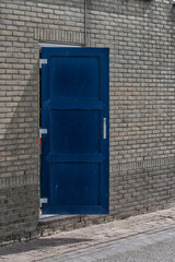 half-open plastic door in the wall of a factory building