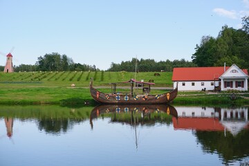 A boat in the shape of an ancient Viking boat near the pier on the river